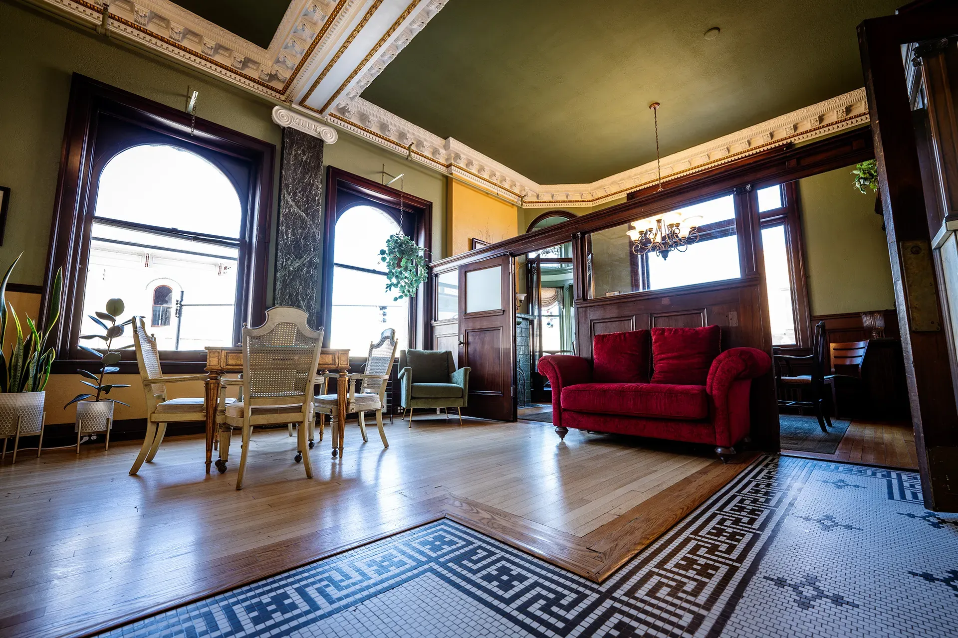 A living room with a red couch and a mosaic floor