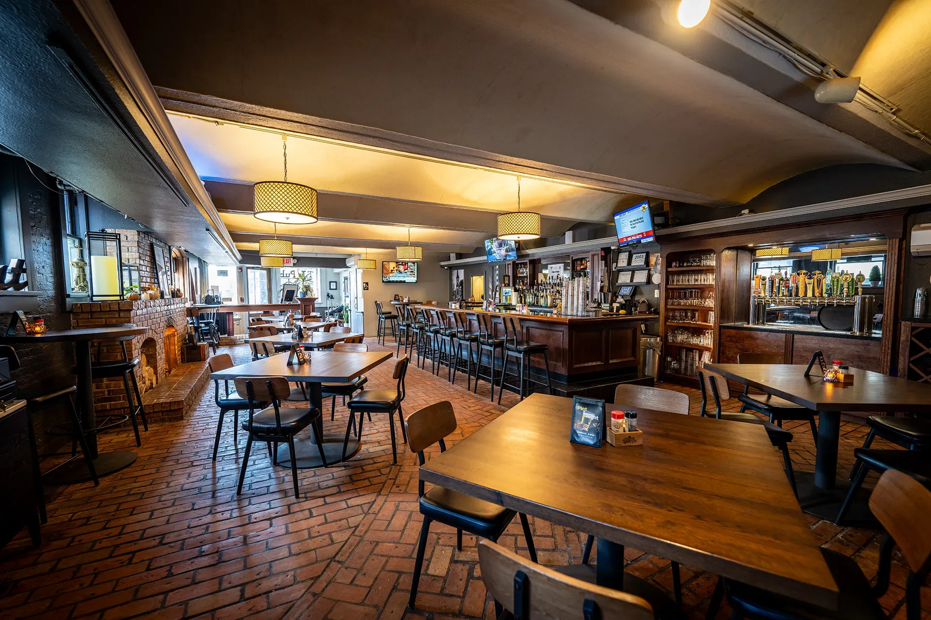 A restaurant with tables and chairs and a bar.