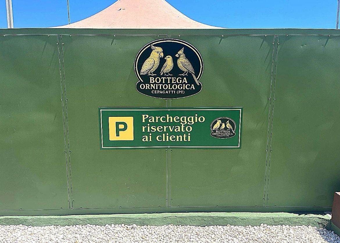 Green metal gate with a “Parcheggio riservato ai clienti” parking sign and “Sofia Boutique Orologi” logo.