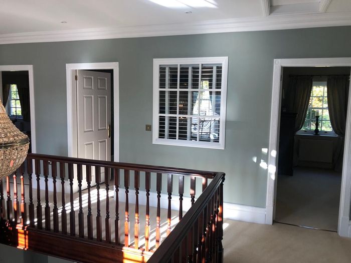 This is a picture of an upstairs landing with fresh grey painted walls by Painters Leicester