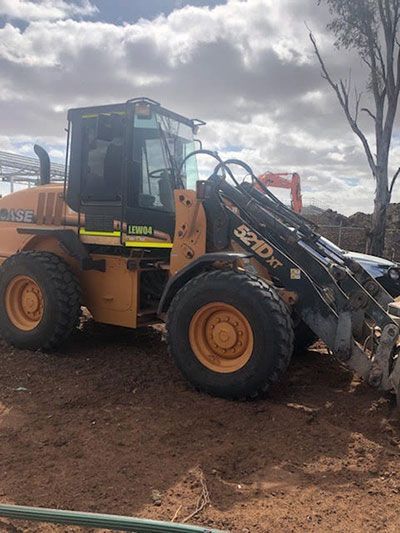 A bulldozer is parked in a dirt field.