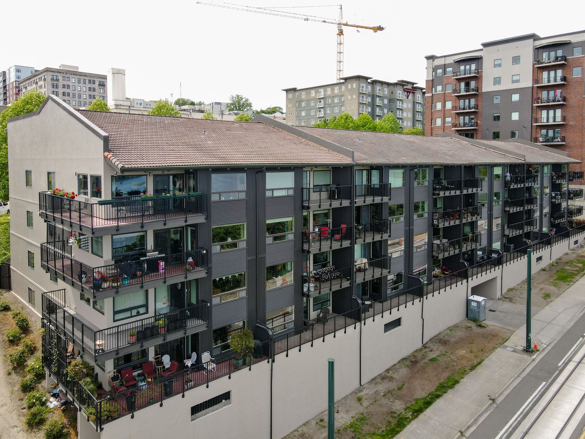 An aerial view of a large apartment building with a crane in the background.