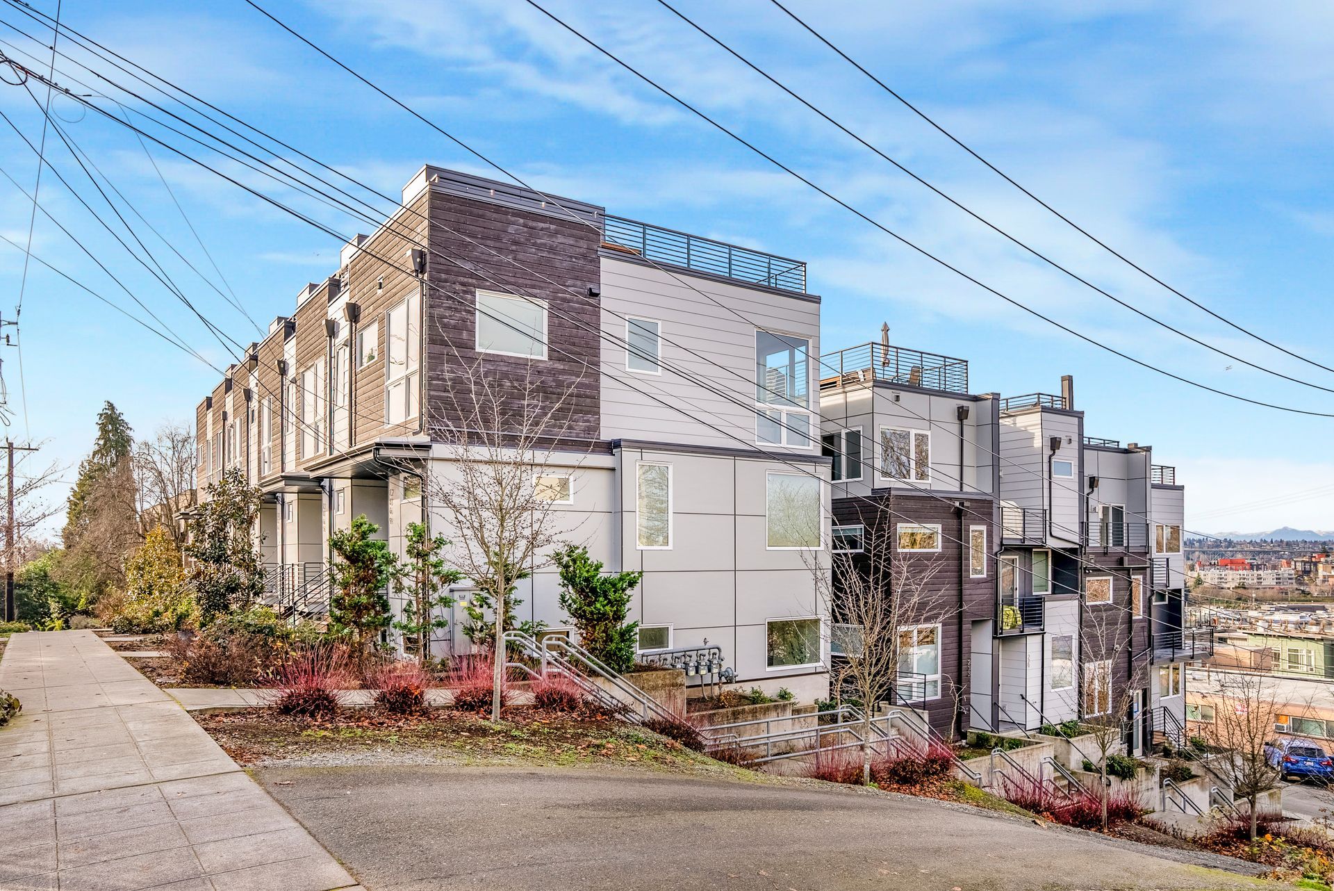 A row of apartment buildings are sitting on top of a hill.