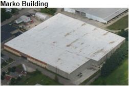 Aerial view of the Marko Building, a large rectangular industrial building with a flat white roof.
