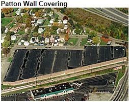 Aerial view of the Patton Wall Covering site, showing large black covered areas and surrounding buildings/road.