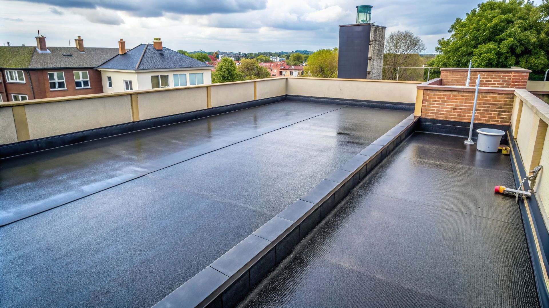 Flat rooftop with black waterproofing and surrounding buildings in view. Flat rooftop with black waterproofing and surrounding buildings in view.