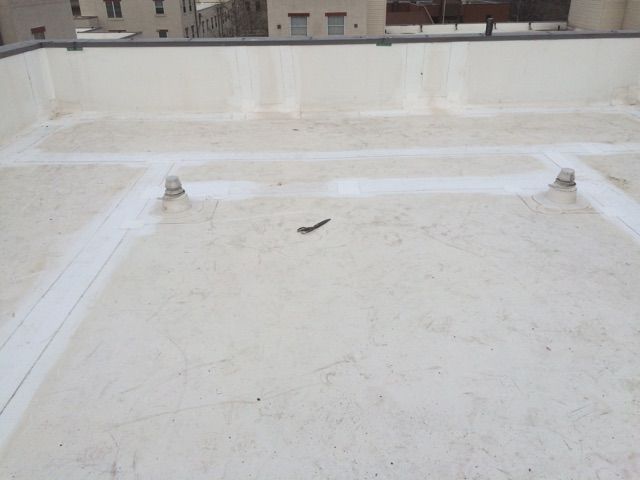 Workers installing waterproofing membrane and asphalt bitumen shingle for flat roof repair. Workers installing waterproofing membrane and asphalt bitumen shingle for flat roof repair.