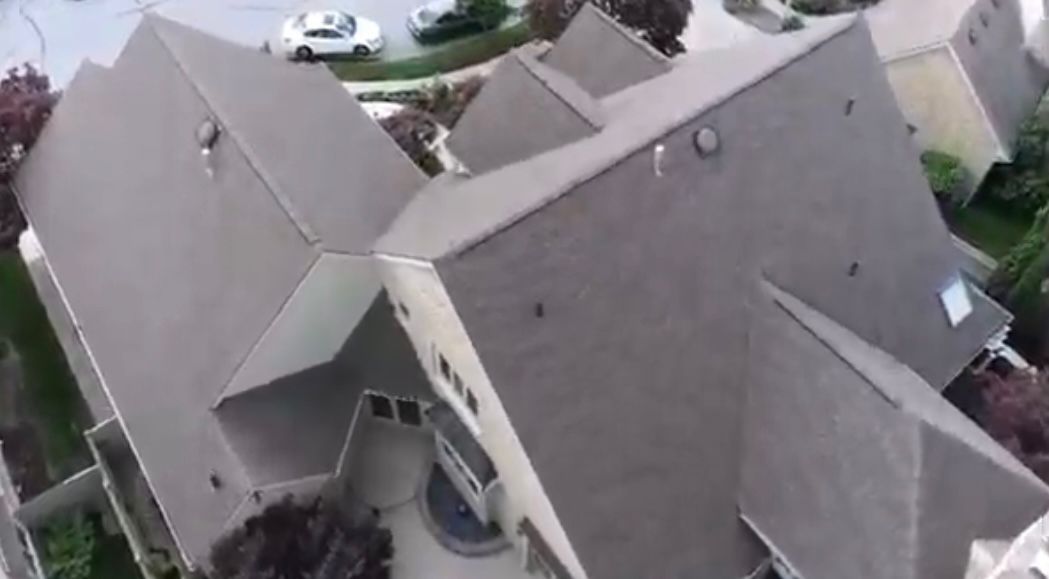 An aerial view of a large house with a gray roof.