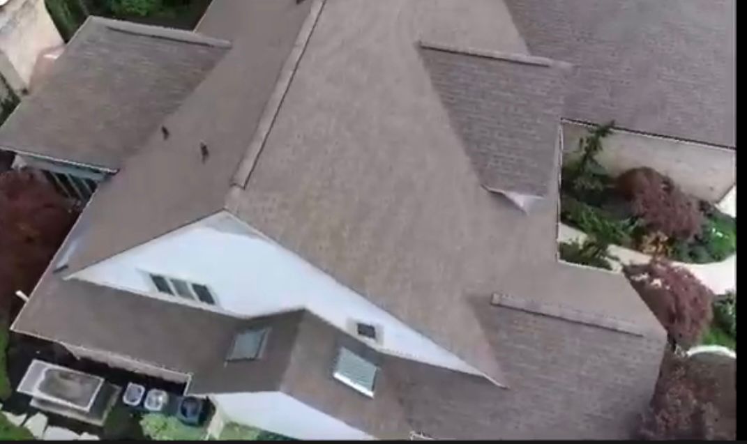 An aerial view of a house with a gray roof.