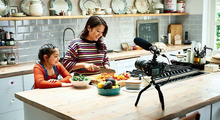 A woman and a child are preparing food in a kitchen.