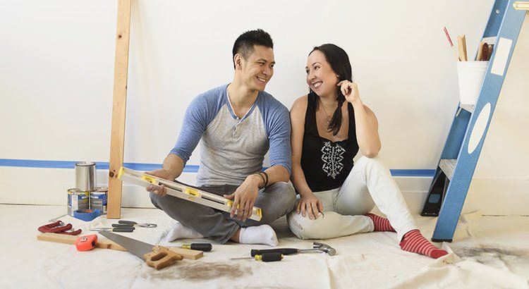 A man and a woman are sitting on the floor looking at each other.