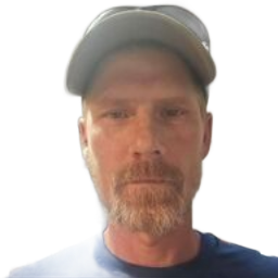 Man wearing a gray cap and blue shirt, facing the camera against a plain white background.