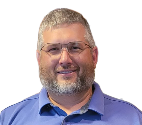 Portrait of a smiling man with glasses and a gray beard, wearing a blue polo shirt