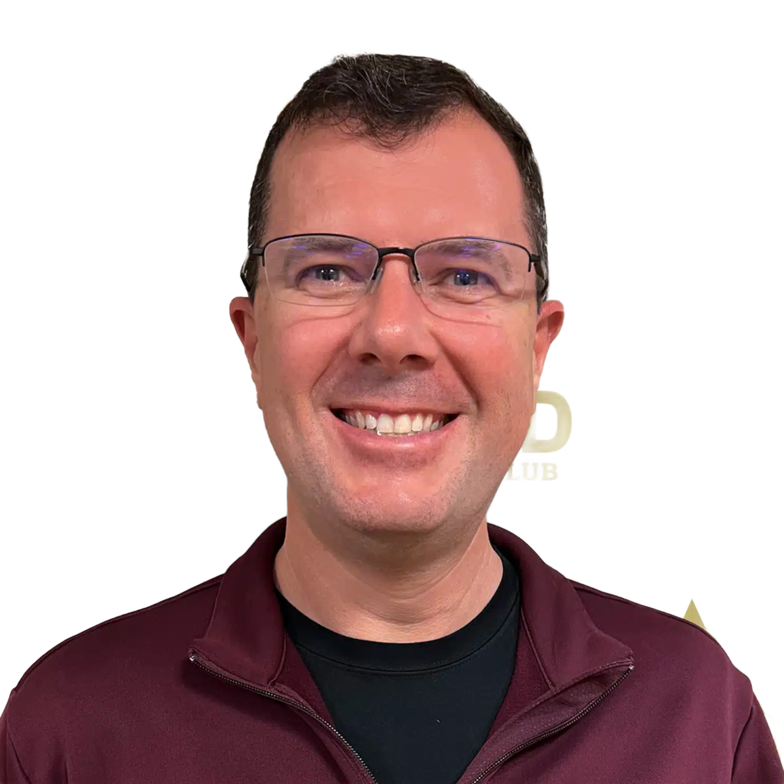 Smiling man wearing glasses and a maroon zip-up top against a white background