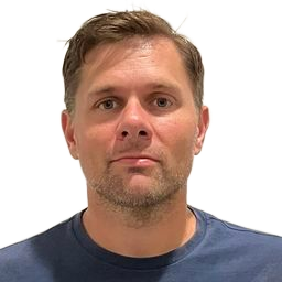 Portrait of a man in a blue shirt against a plain white background