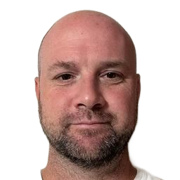 Close-up portrait of a bald man with a short beard against a plain white background