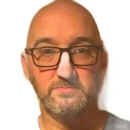 Close-up portrait of a bald man wearing glasses, with a gray beard, against a white background