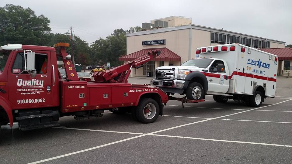 a quality tow truck is towing an ambulance