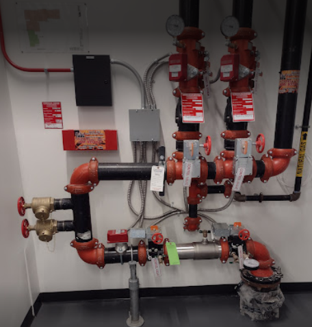 A room with a lot of pipes and a sign that says fire alarm