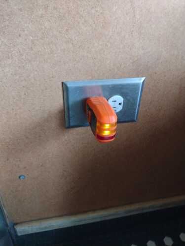 A light is plugged into an electrical outlet on a wall.