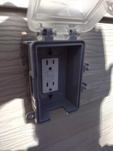 A gray plastic box with a electrical outlet inside of it.