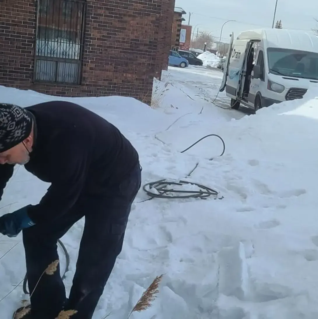 Un homme travaille dans la neige près d'une camionnette