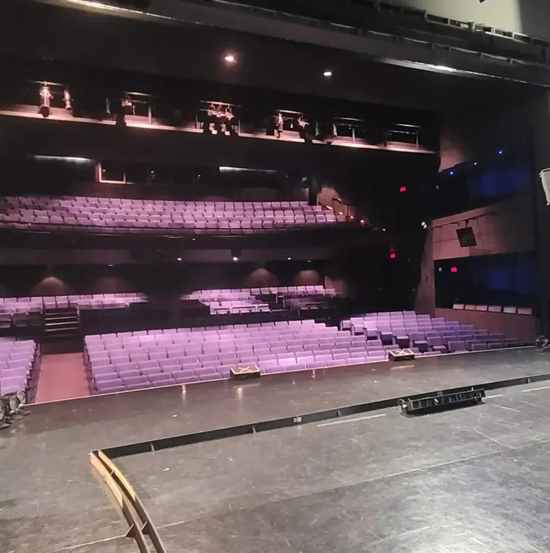 Un théâtre vide avec des sièges violets et une scène