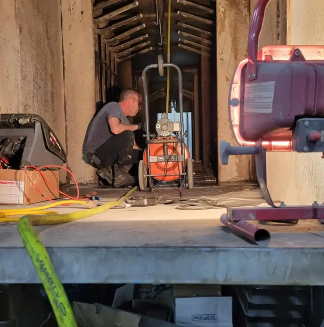 Un homme est à genoux devant une machine sur laquelle est écrit « Simpson »