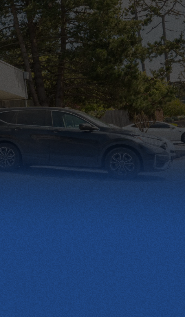 Blue SUV parked on a street with trees and other cars in the background | Pacific Motor Service