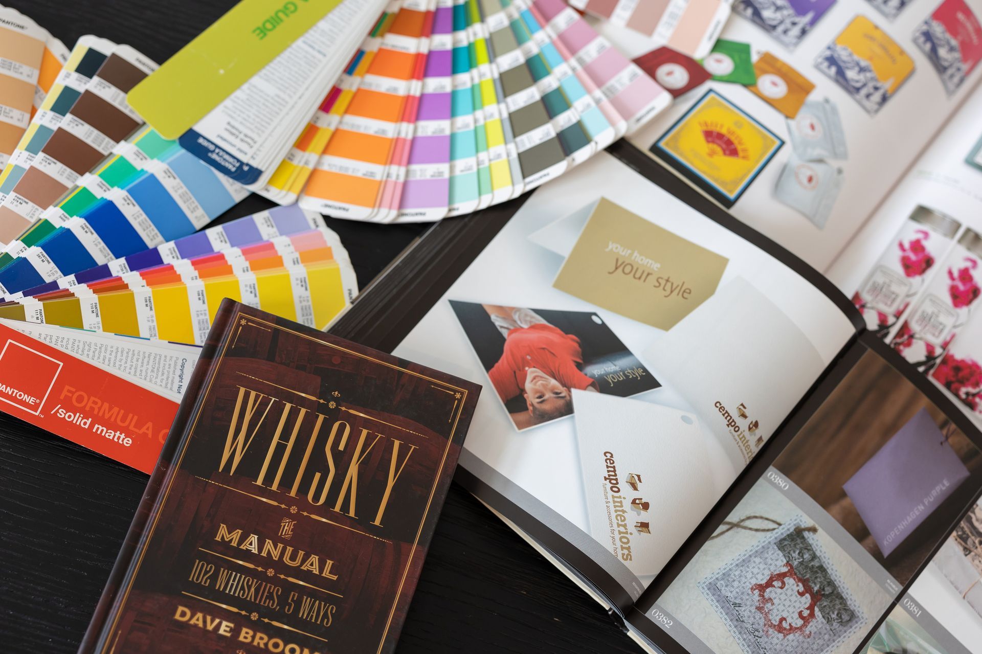 A spread of design tools with color swatches, a catalog, and a book titled 