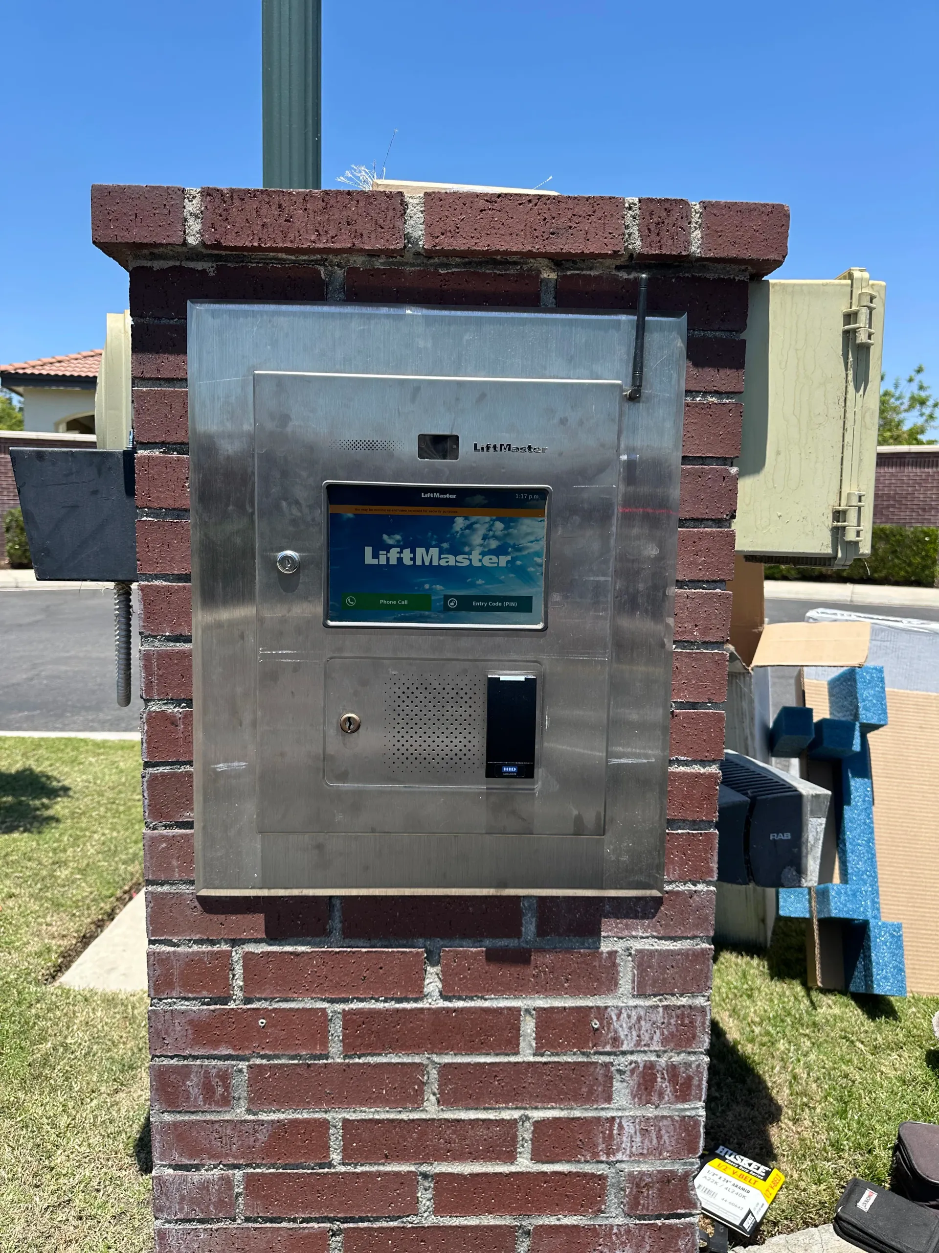 Brick utility box with a metal access panel and meter in a grassy outdoor Bakersfield area