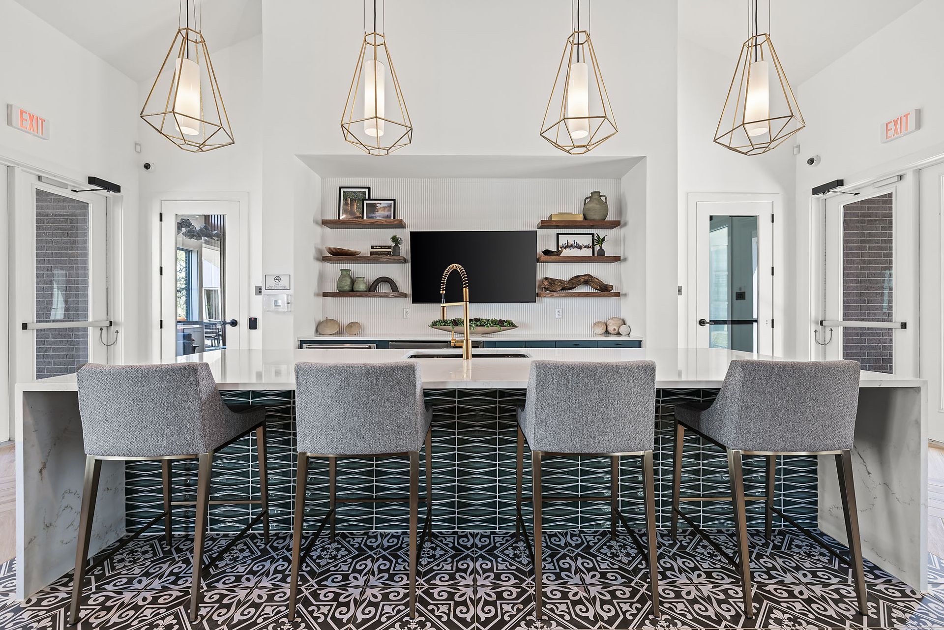 Apartment community kitchen with a bar and chairs and a television on the wall at The Everett, offering apartments for rent in Northwest Austin, TX.