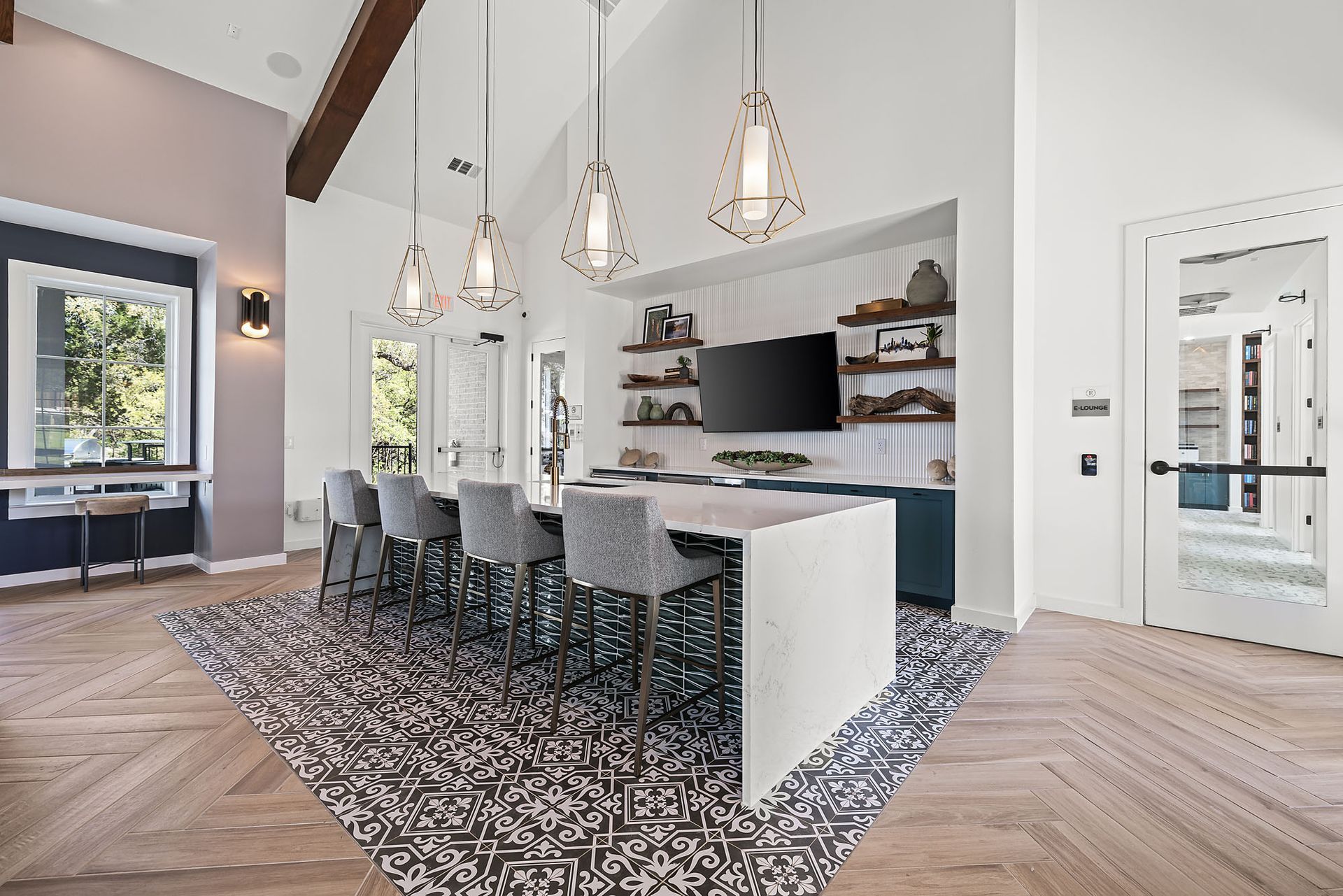 A large clubhouse room with a long table and chairs and a television on the wall at The Everett, offering apartments for rent in North Austin, TX.