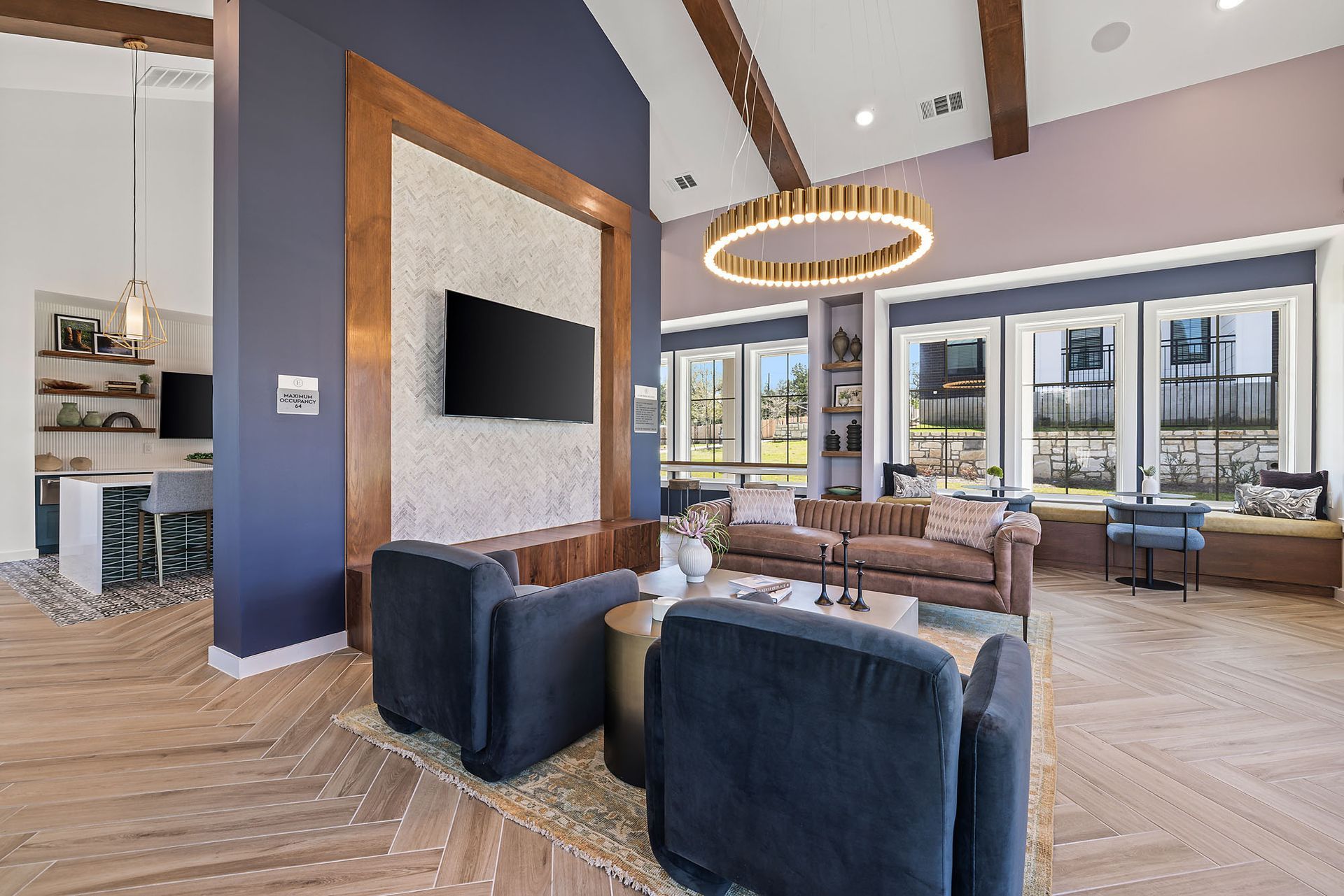 Apartment clubroom with a couch, chairs, and a flat screen TV at The Everett, offering apartments for rent in Austin.