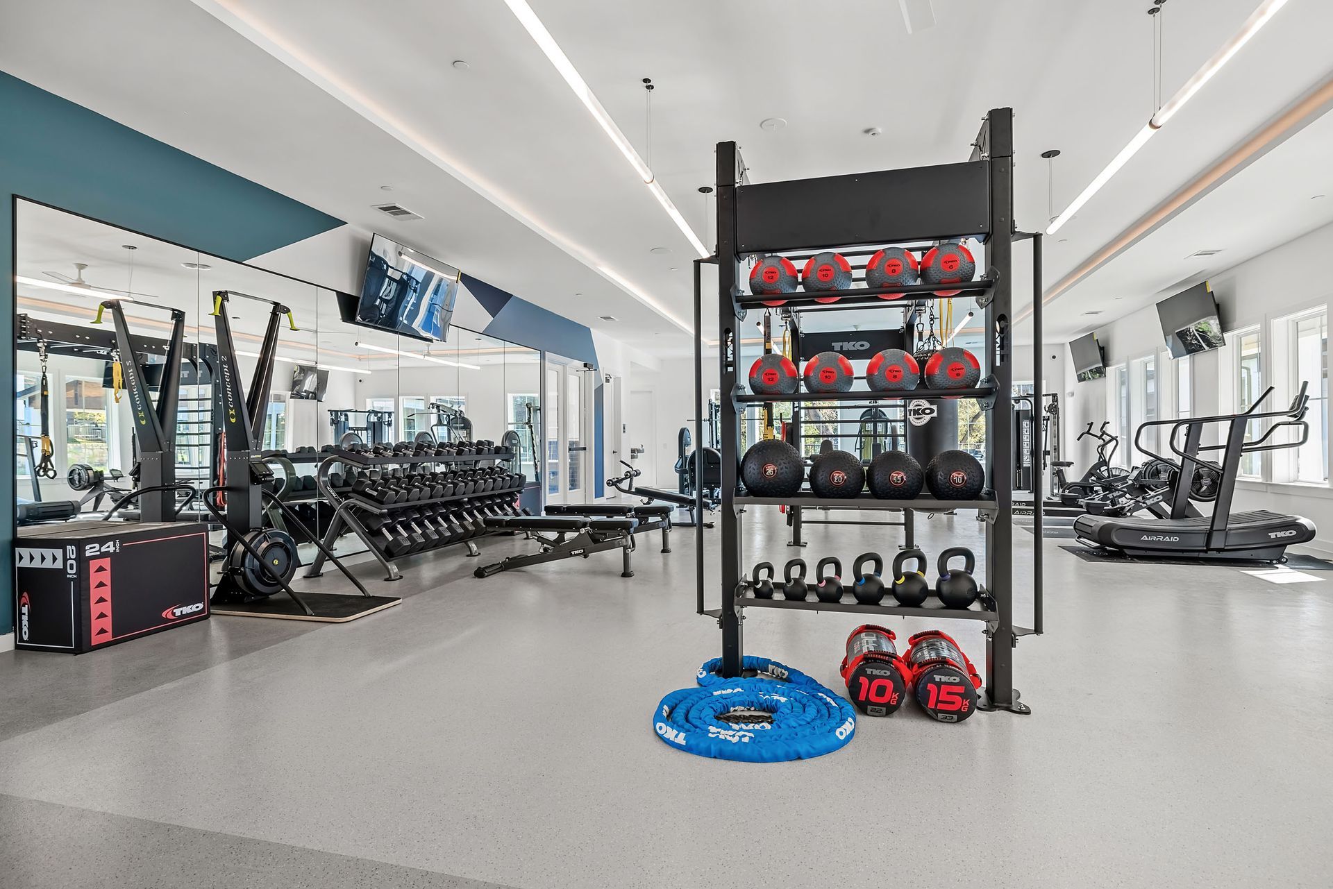 A large gym with a lot of equipment and a rack of dumbbells at The Everett. offering apartments in Northwest Austin, TX.