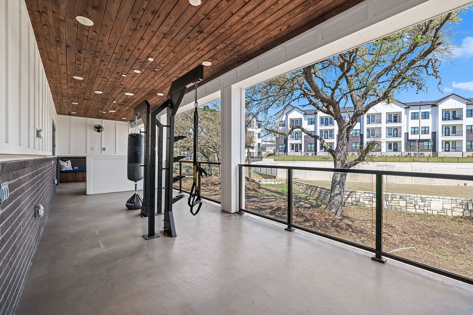 There is a balcony with a view of the apartment building and trees at The Everett, offering apartments for rent in Northwest Austin, TX.
