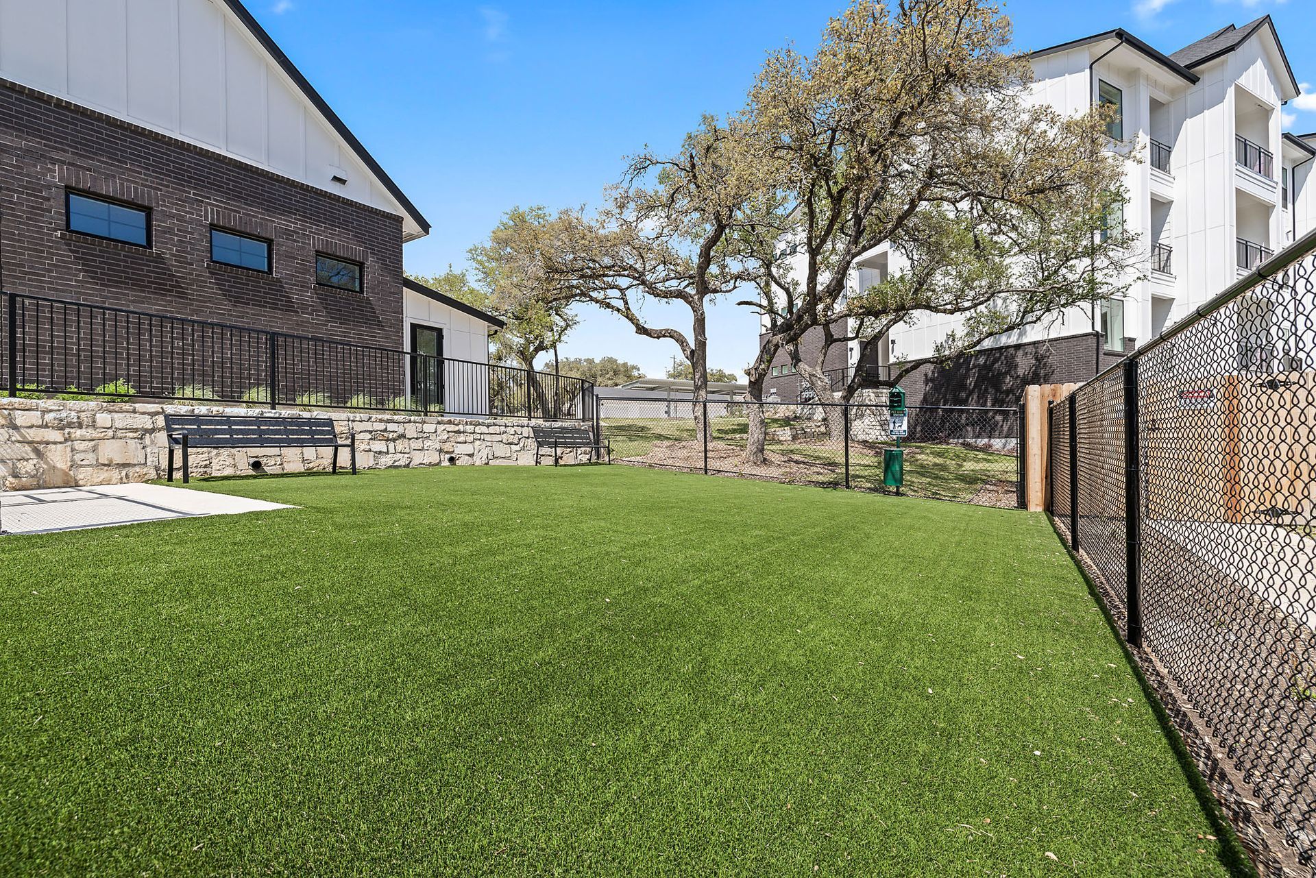 There is a dog park in front of a building at The Everett, offering pet-friendly apartments in Northwest Austin.
