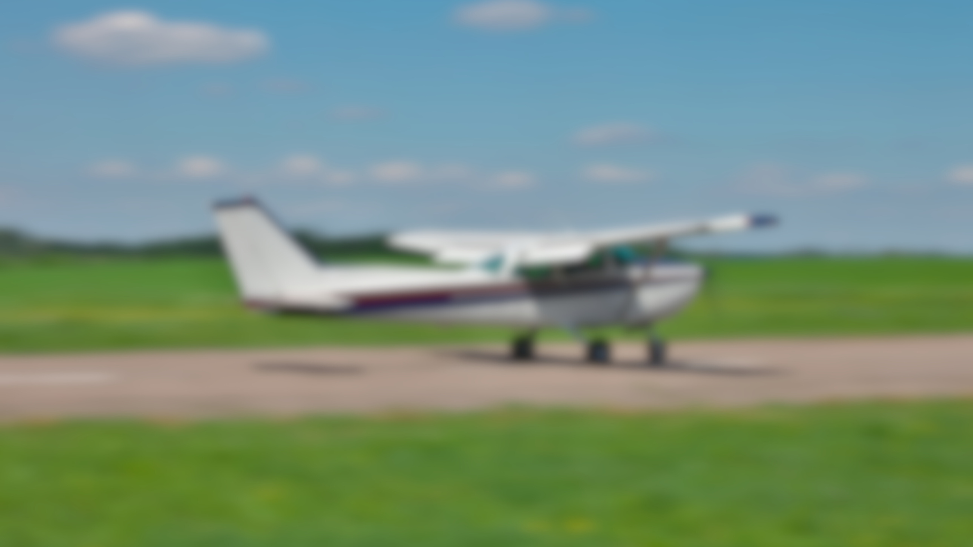 A small plane is sitting on a runway in a field.