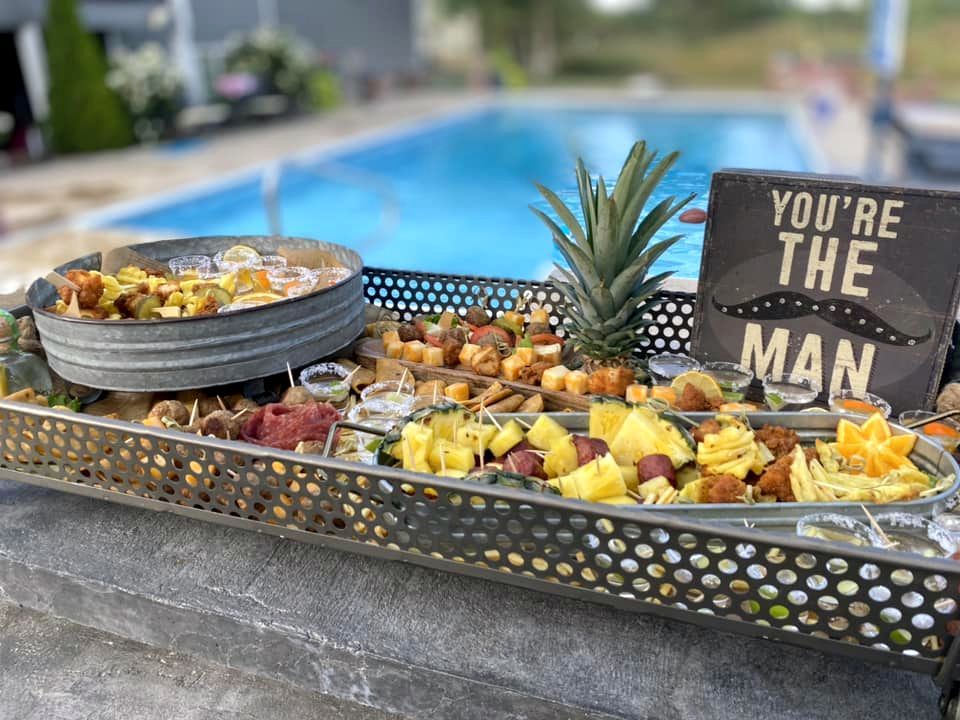 A tray of food with a sign that says `` you 're the man '' next to a pool.