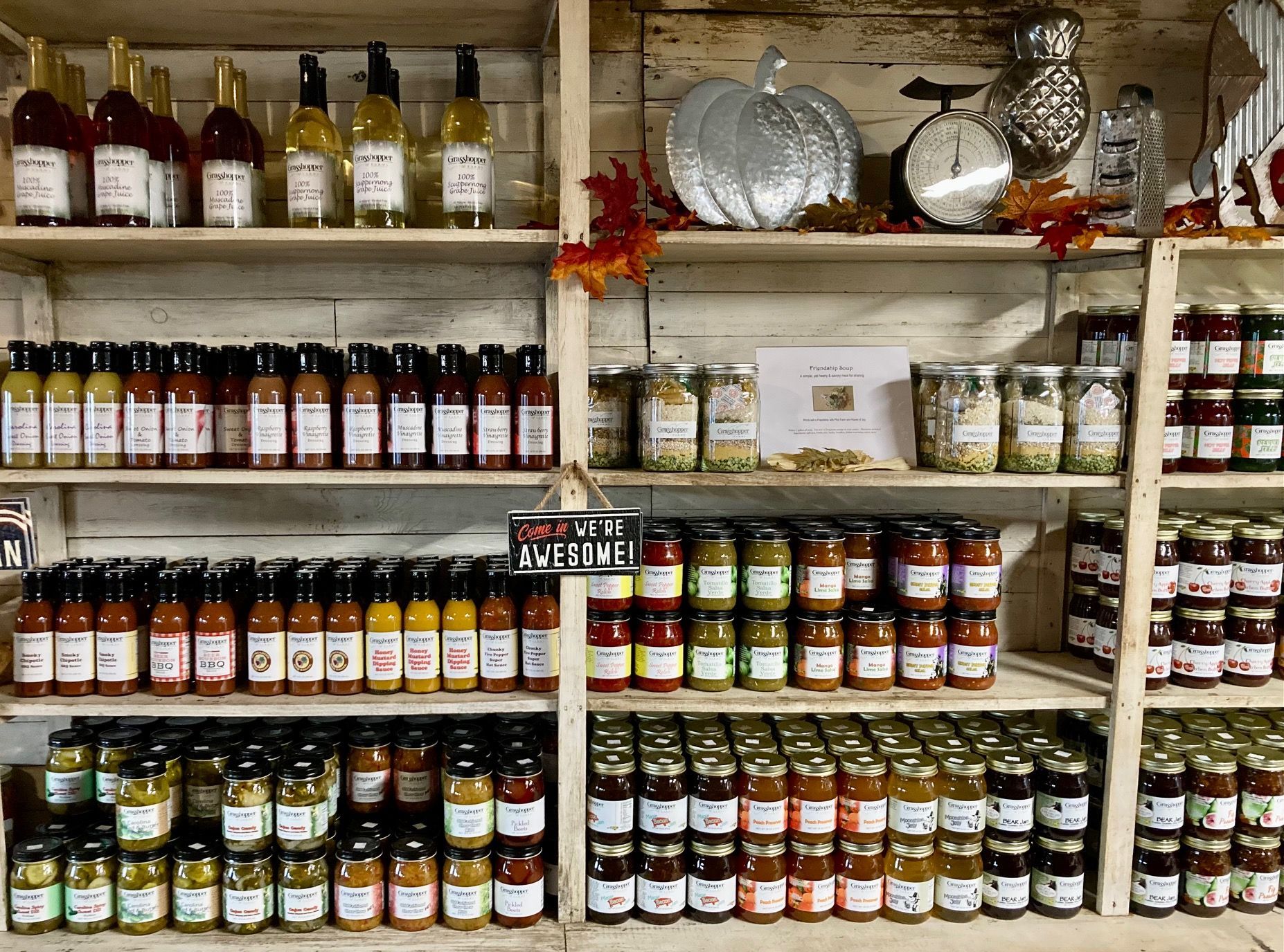 Shelves stocked with assorted bottles and jars in a store or market display. Grasshopper Farms Knightdale, NC