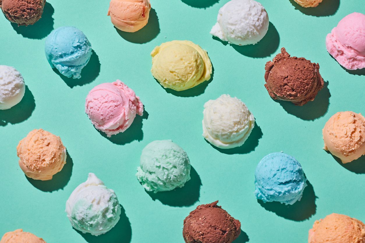 Colorful scoops of ice cream scattered on a mint green background | Grasshopper Farms Knightdale, NC
