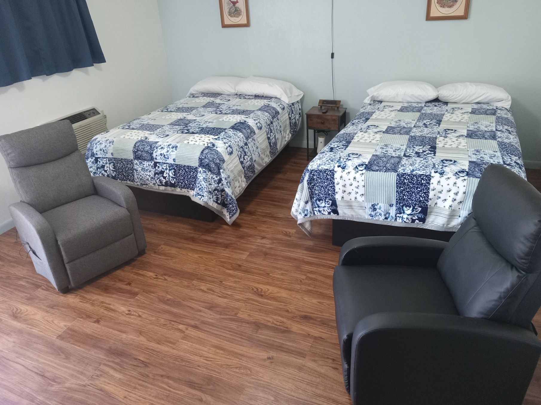 There are two beds and a chair in the room.