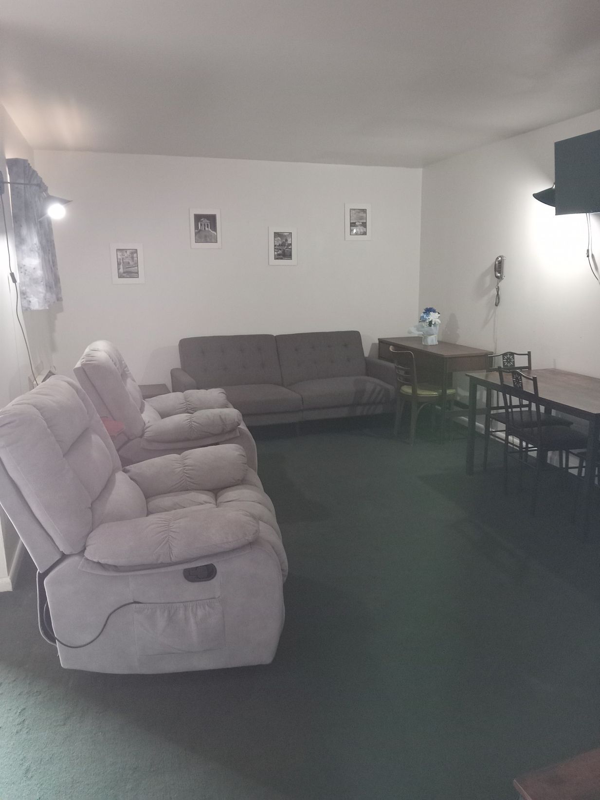 A living room with a couch , chairs , and a table.