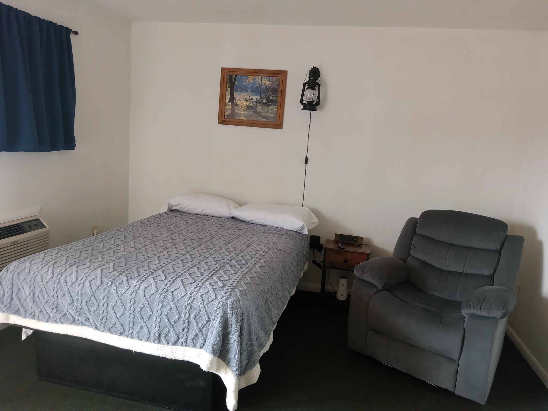 A bedroom with a bed and a chair in it