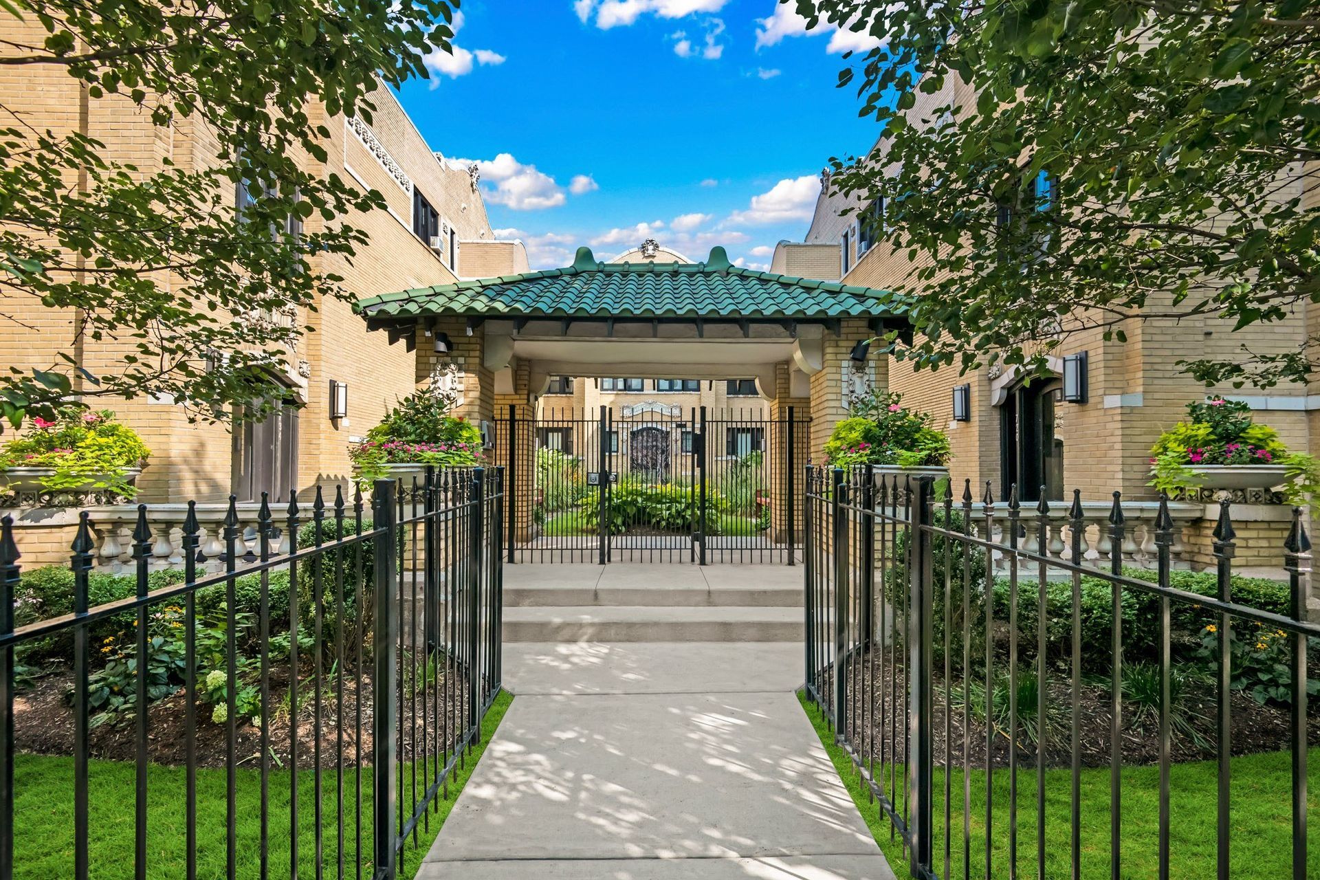 a gated entrance to a building with a gazebo in the front