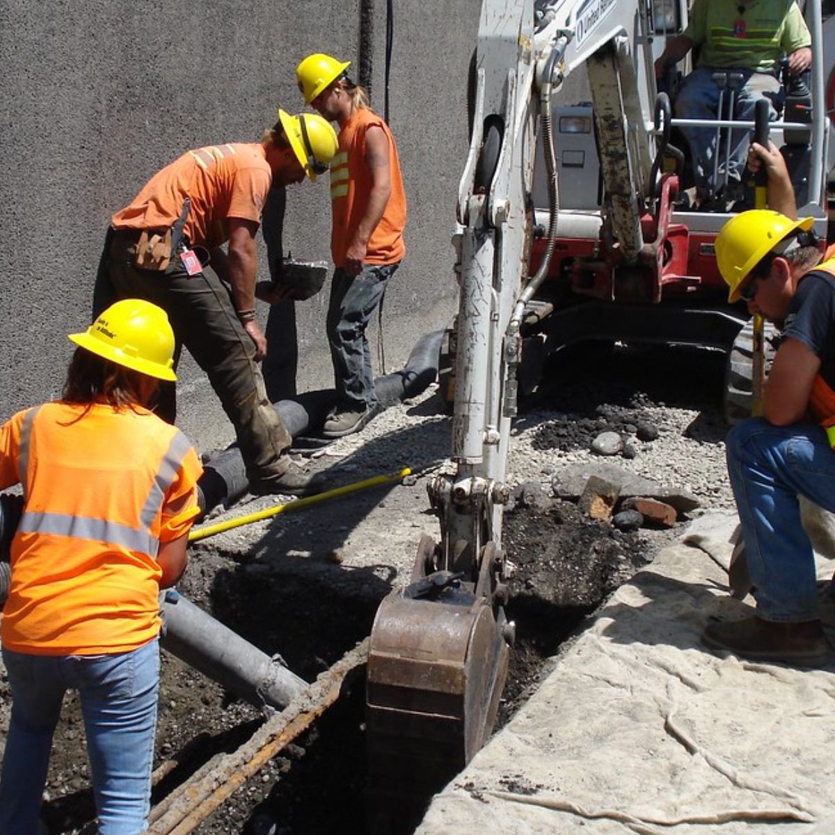 A group of construction workers wearing yellow hard hats