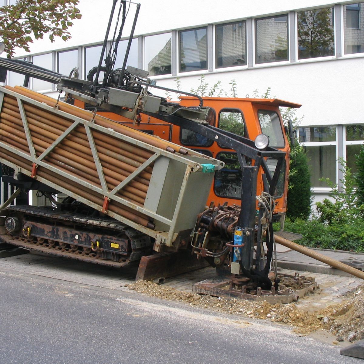 An orange truck is parked on the side of the road