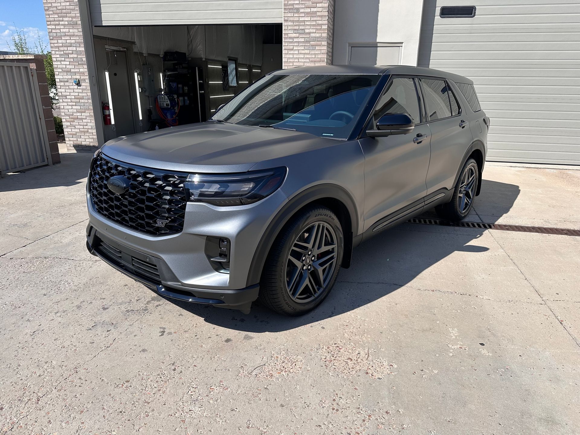 A ford explorer is parked in front of a garage.