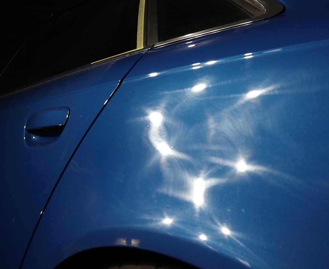 A close up of a blue car with a lot of sparkles on it