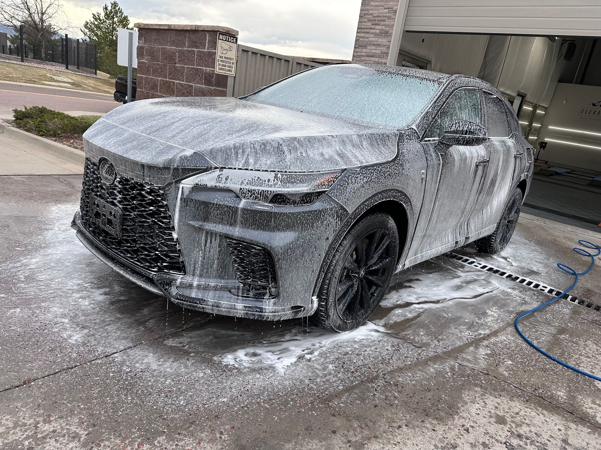 A car is covered in foam at a car wash.